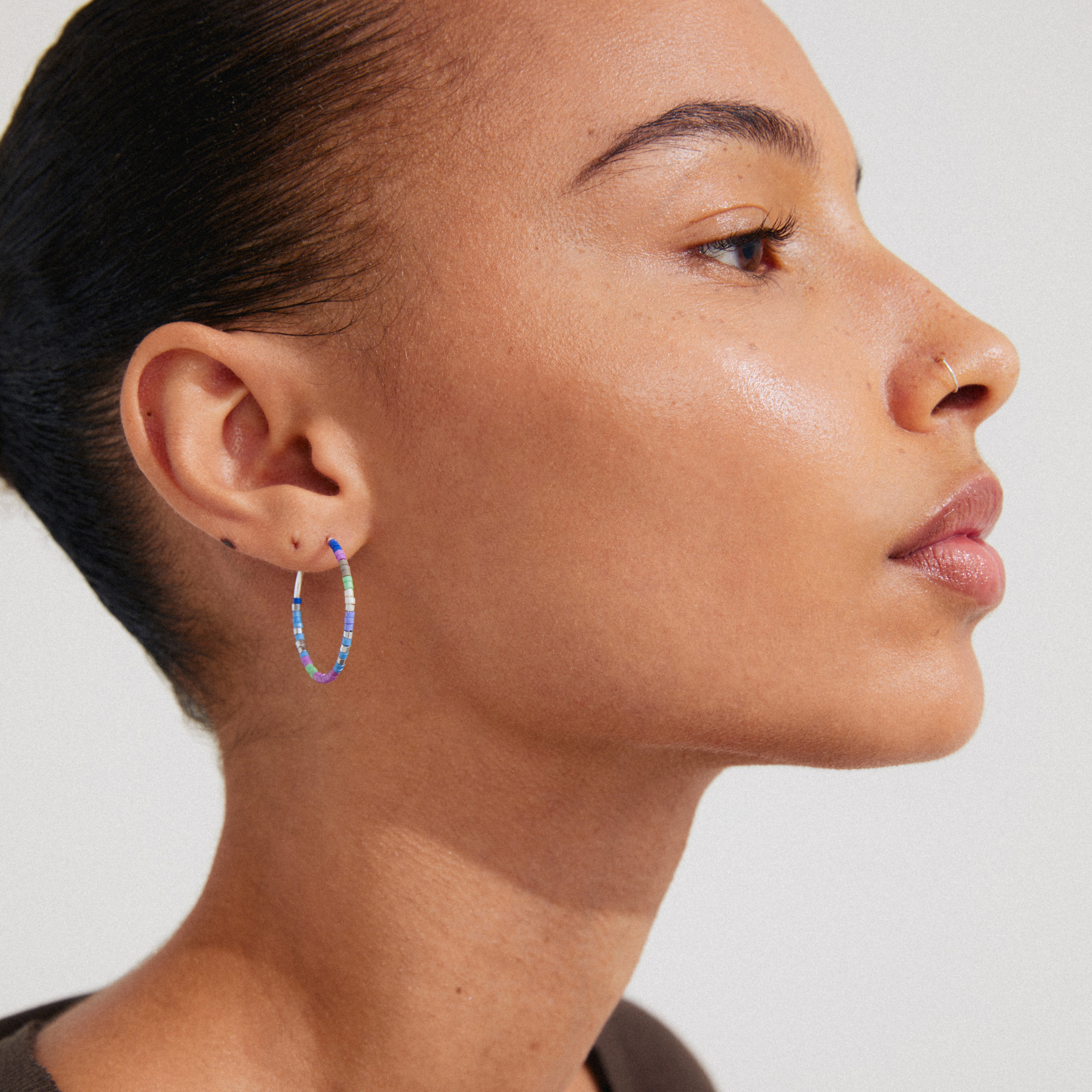 ALISON hoop earrings in blue and silver-plated, featuring glass beads, shown worn by a woman. A trendy, optimistic accessory from Pilgrim's collection.