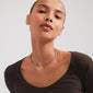 Woman wearing Pilgrim's ALISON necklace, featuring purple glass beads and a silver-plated chain, styled close to the neck for a layered look.