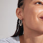 LARISA earrings silver-plated, featuring twisted hoops with a boho vibe, worn by a woman. Eye-catching, sustainable design from Pilgrim's handmade Danish jewelry collection.