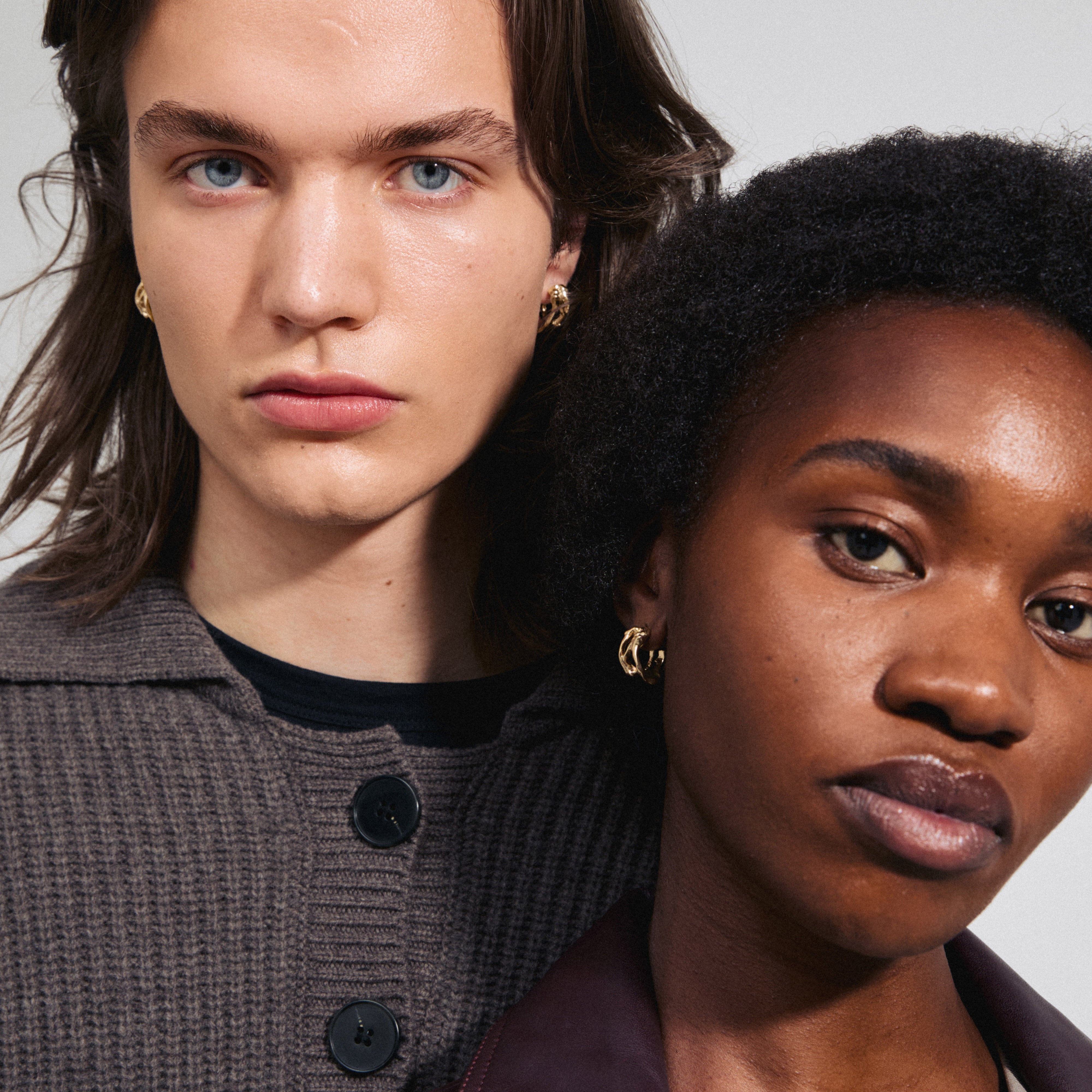 FOTINI gold-plated hoop earrings showcase an organic design, worn by a woman in a stylish portrait, reflecting Pilgrim's elegant craftsmanship.