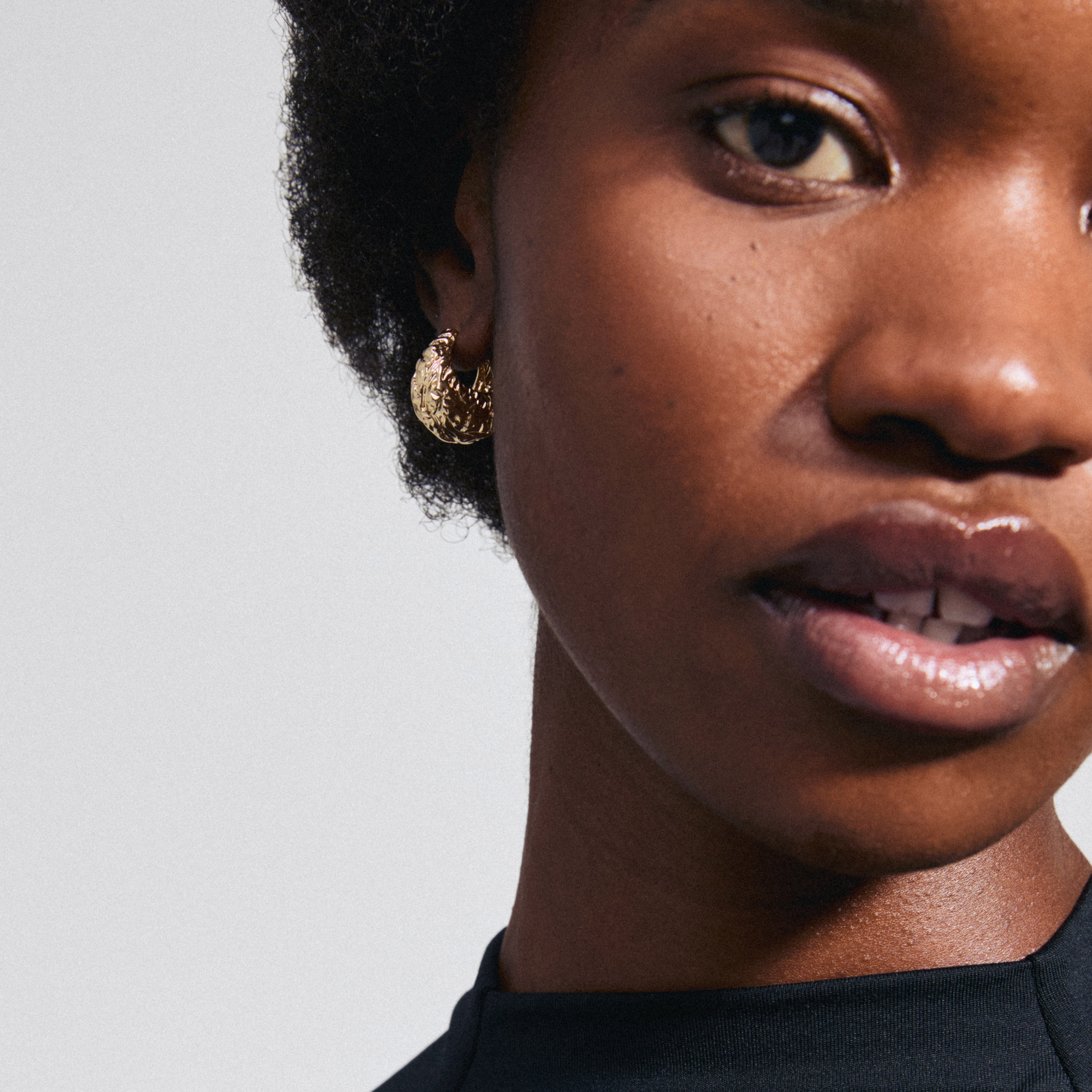 LINCOLN gold-plated earrings by Pilgrim, featuring wide hoops with a rustic look and shiny finish, perfectly complementing everyday style with a trendy, chunky silhouette.