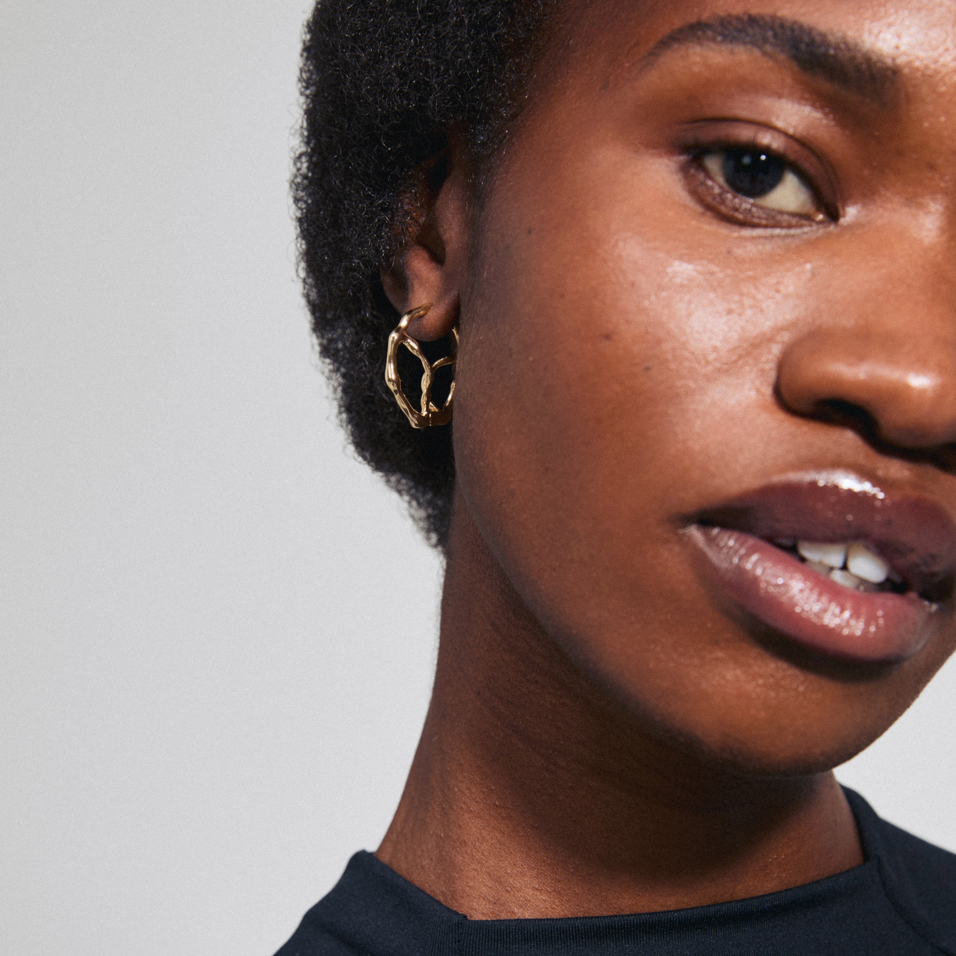 Gold-plated DIDO hoop earrings from Pilgrim, featuring a modern organic design with unique details and a convenient click clasp. Perfect for adding an optimistic touch.