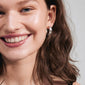 Woman smiling, showcasing BENNETT hoop earrings silver-plated from Pilgrim, highlighting their classic, wide design and urban-inspired simplicity.