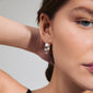 Close-up of a woman wearing BENNETT silver-plated hoop earrings, showcasing their wide, classic design with a modern Scandi touch.