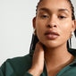 Woman wearing silver-plated RORY earrings, chunky oval half-hoops with a vintage vibe, highlighting Pilgrim's blend of trendy and timeless Scandinavian design.