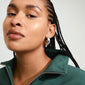 Close-up of a woman wearing Pilgrim's RORY silver-plated earrings, showcasing chunky oval half-hoops with a vintage vibe, made from 97% recycled material.