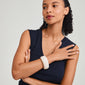 Woman wearing the AASE maxi bangle beige by Pilgrim, a chunky, recycled acrylic bracelet, styled with a black shirt for a chic, minimalist look.