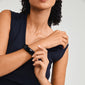 Woman wearing Pilgrim's AASE bangle black, a recycled acrylic bracelet, highlighting a minimalist Scandi style, perfect for stacking with summer outfits.