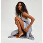 Woman in a grey dress showcasing the JOANNA silver-plated anklet, a flat snake chain adding a luxurious touch to summer outfits.
