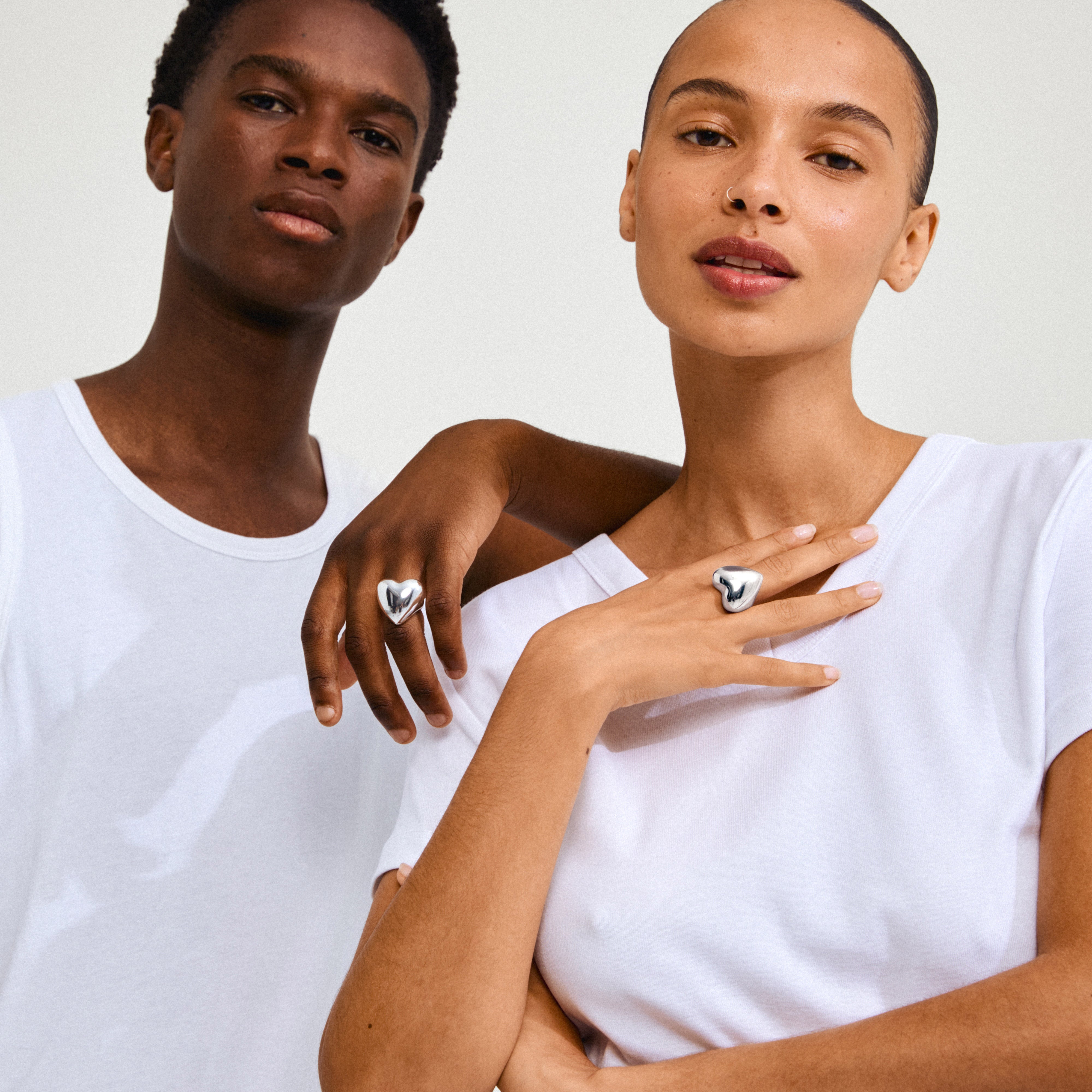 Close-up of a woman wearing the silver-plated ANNEMETTE ring by Pilgrim, featuring a bold heart design as a standout fashion accessory.