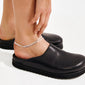 JELONA ankle chain silver-plated: Double-strand herringbone chains catch light, elegantly layered on a bare ankle, paired with a black leather mule. Perfect for summer style.