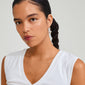 Silver-plated APPOLLONIA earrings featuring slim hoops and tube-shaped glass beads, worn by a woman with braided hair, showcasing a laid-back summer style.