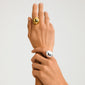 Close-up of two hands wearing Pilgrim's JAMESON ring, featuring a gold-plated, smooth domed design, highlighting its adjustable fit and sustainable, stylish craftsmanship.
