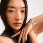 Young woman showcases Pilgrim's ARASH pearl bracelet gold-plated, elegantly stacked on her wrist, highlighting its sleek design with pearl-colored glass beads.