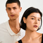 Close-up of a young man and woman wearing RYLEE gold-plated stud earrings, showcasing minimalist style with boho chic triangles featuring an all-seeing eye design.