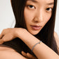 Close-up of a woman wearing the INDIE bracelet in dusty blue with gold-plated details, showcasing Pilgrim's trendy and timeless design.