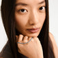 Woman wearing the INDIE bracelet with dusky blue faceted glass beads and a gold-plated logo, highlighting its elegance and versatility for any occasion.