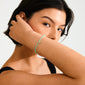 Woman showcasing the INDIE bracelet in mint green with gold-plated accents, featuring faceted glass beads on her wrist. Perfect for stacking and personal style.