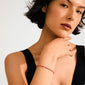 Close-up of a woman wearing the INDIE bracelet, featuring peach faceted glass beads and a subtle gold-plated Pilgrim logo, capturing light beautifully.