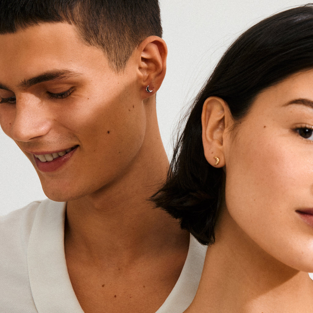 Close-up of a woman's ear wearing silver-plated crescent moon earrings from Pilgrim, showcasing their rustic design and minimalist appeal.