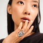 Young woman showcasing the ADRIEL silver-plated ring with an artsy, fluid design on her middle finger, highlighting its shiny, sculptural elegance against minimal styling.