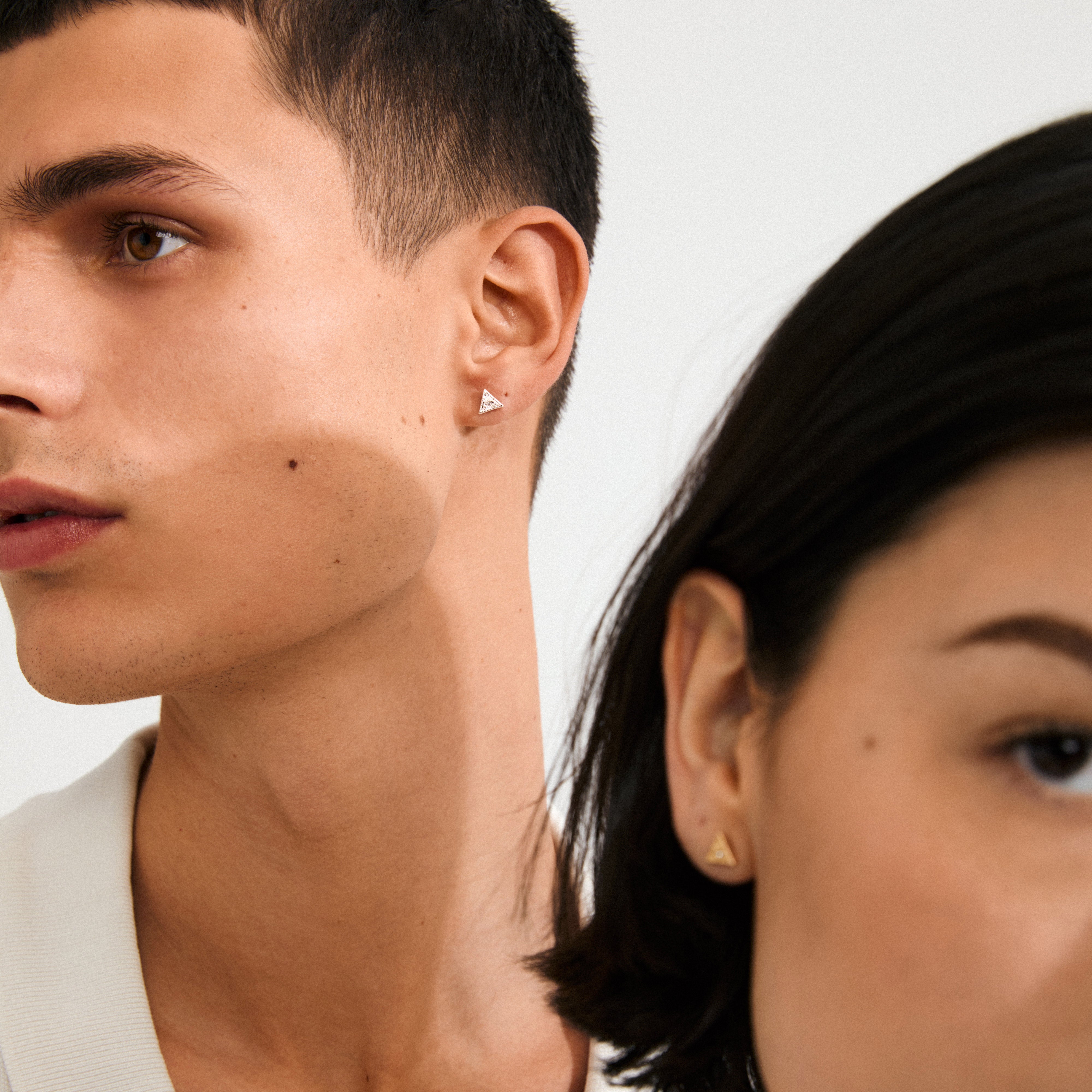 Two models wear Pilgrim's RYLEE earrings, featuring small, silver-plated triangular studs, perfect for a chic, boho-inspired look.