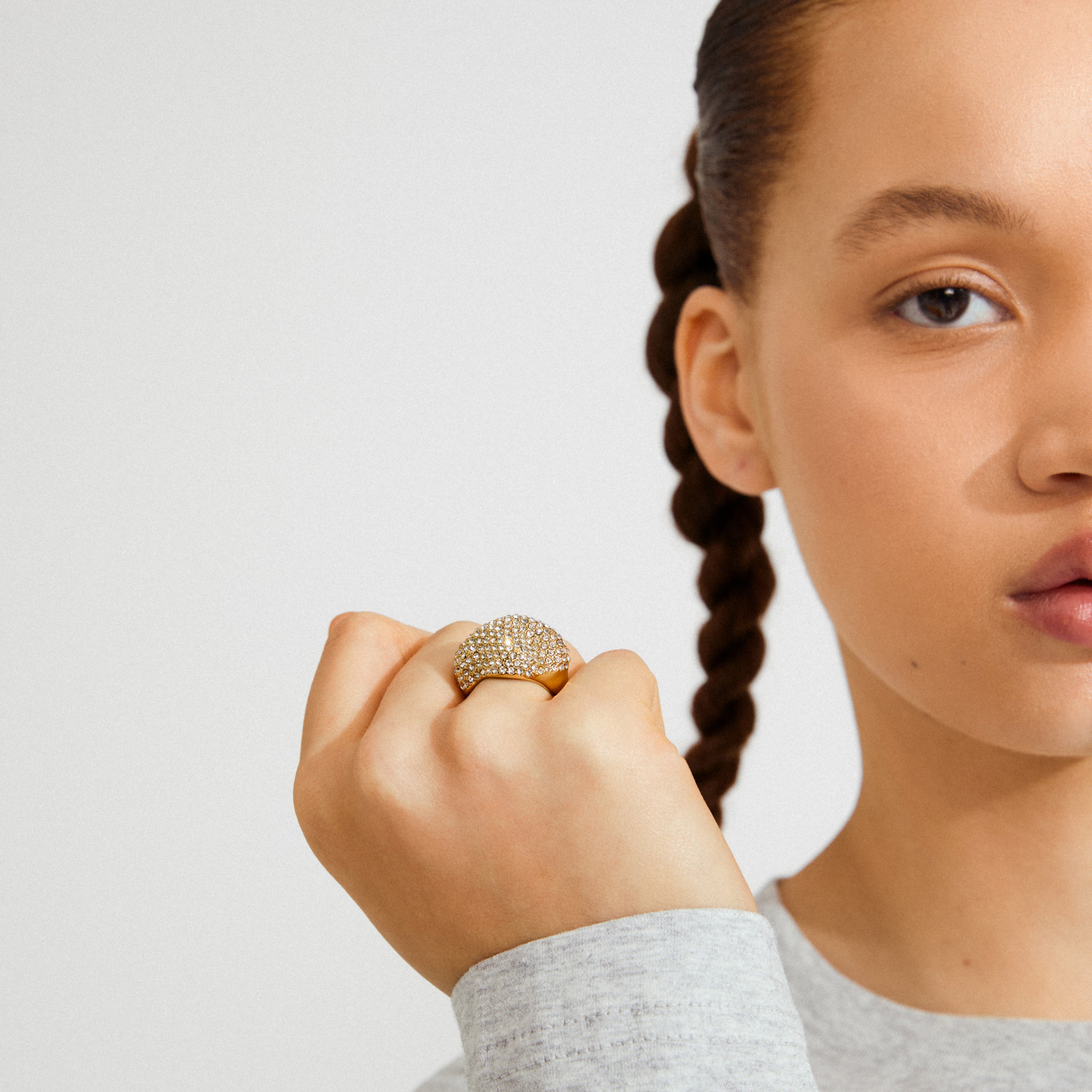 Close-up of a person wearing the gold-plated LAEL ring by Pilgrim, showcasing its pavé-style dome encrusted with sparkling Preciosa crystals.