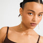 Young woman wearing Pilgrim's BASIL gold-plated drop earrings adorned with Preciosa crystals, showcasing a luxurious and dynamic silhouette for an effortlessly sophisticated look.