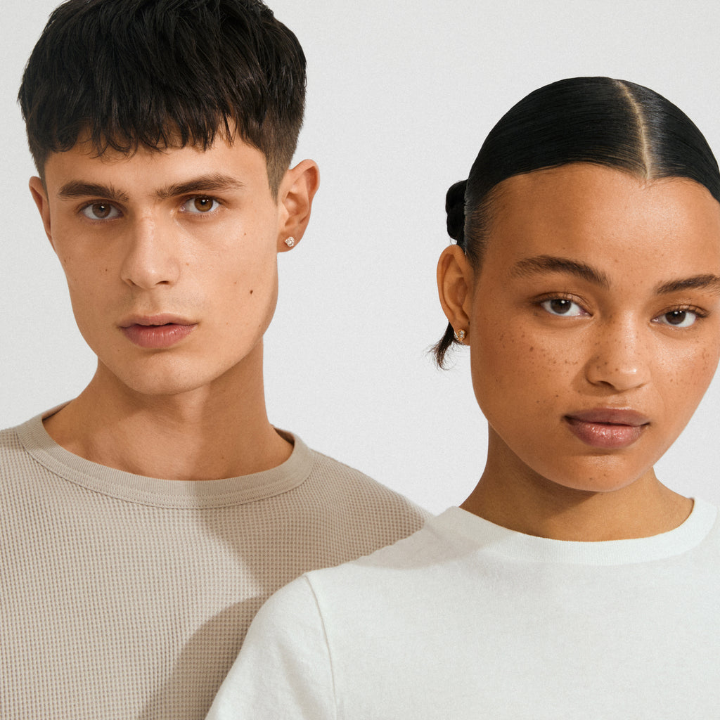 Two young adults wearing KOTA silver-plated earrings by Pilgrim, featuring nature-inspired settings with sparkling crystals, highlighting a stylish yet subtle look.
