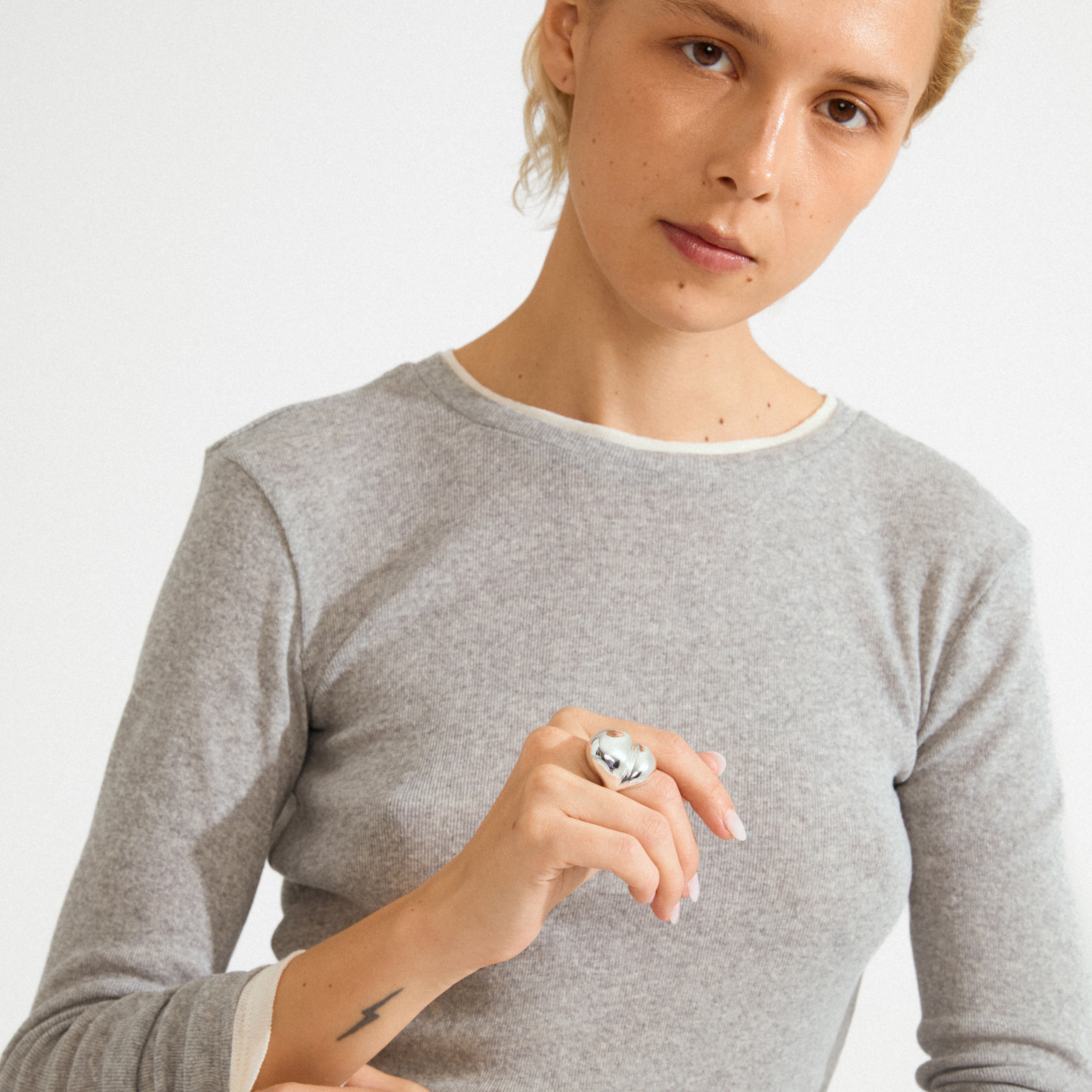 Person showcases the MADDIX ring, a silver-plated, chunky, wave-shaped design, highlighting its bold, artistic style; perfect for elevating minimalist looks.