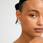 Young woman wearing Pilgrim's MAYER silver-plated chunky hoop earrings, showcasing their iconic curb chain design against her smooth, freckled skin and braided hairstyle.