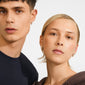 Close-up of two young adults wearing Pilgrim's SOUL earrings, silver-plated with sparkling crystals, showcasing their heart shape and elegant design.