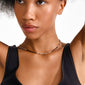 Close-up of a woman wearing the ALISON necklace from Pilgrim, featuring slim black and gold beaded design, complementing her black ribbed tank top.