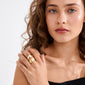 Young woman showcases the ALMA ring gold-plated, featuring wide, smooth design on her fingers, accentuating minimalist elegance and contemporary style.