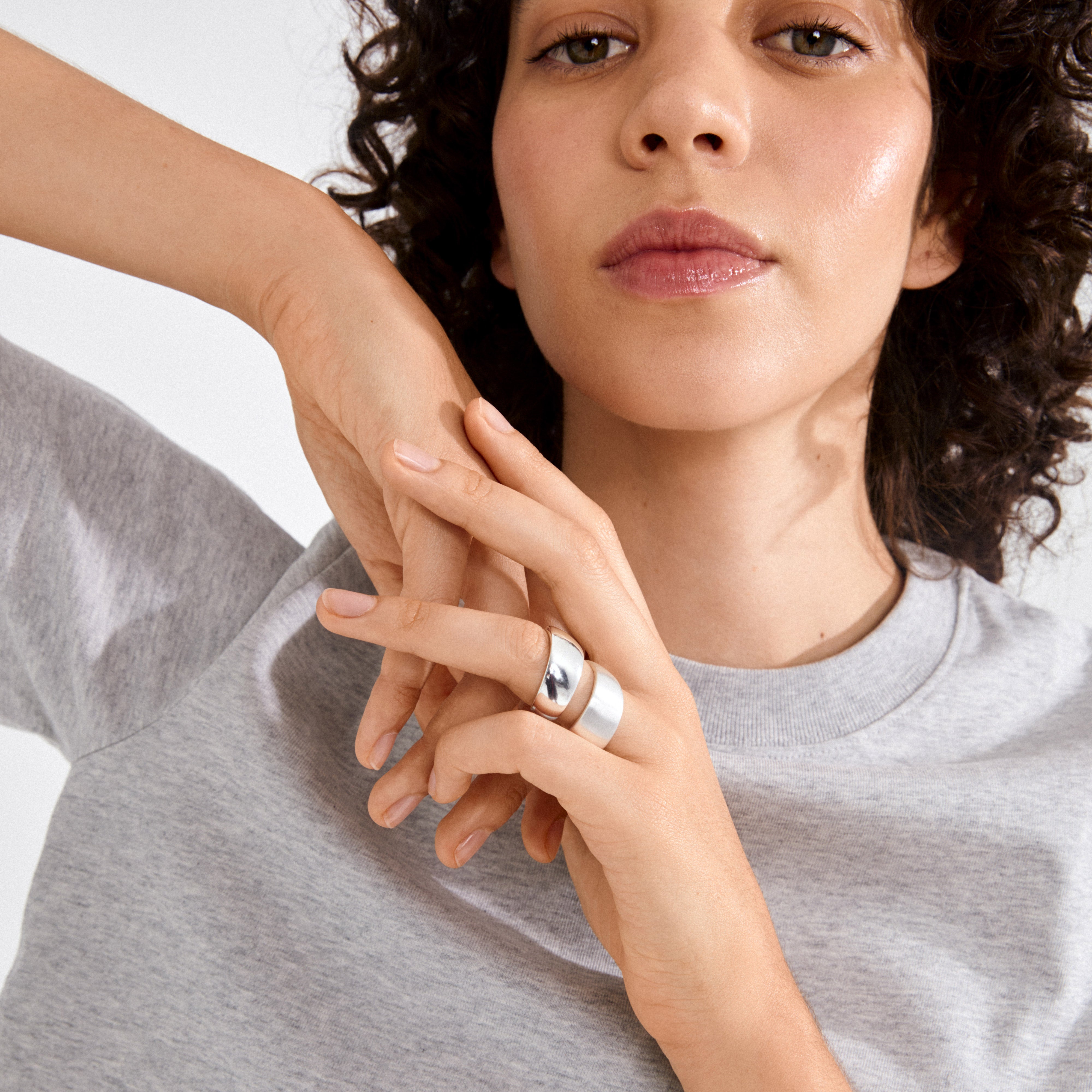 Young person wearing the ALMA ring silver-plated, showcasing its sleek, minimalist design with polished dome and flat band, highlighting contemporary style and sustainability.