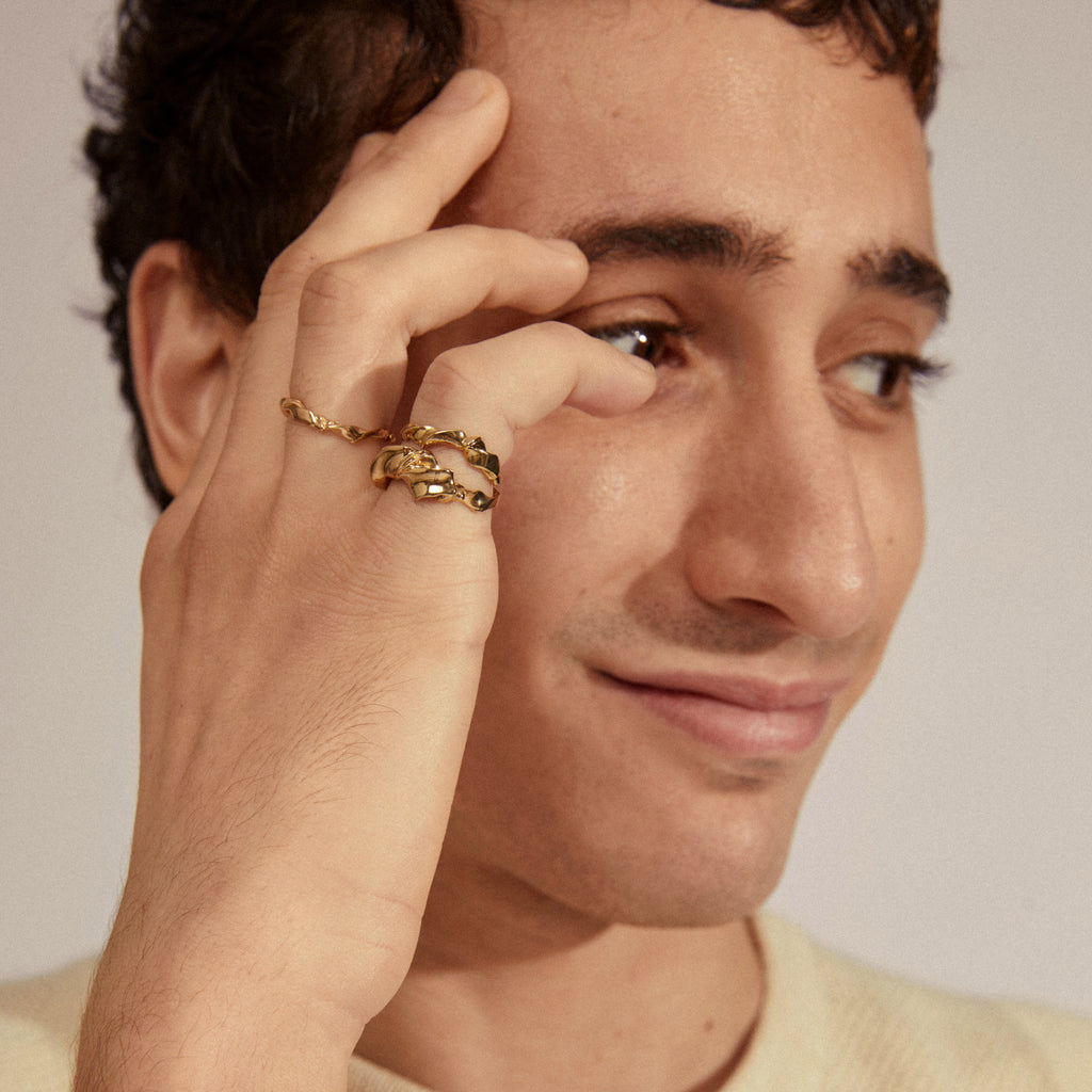 STORM rings 3-in-1 set gold-plated, featuring interconnected, handcrafted uneven surfaces, elegantly adorns a hand, showcasing Pilgrim's blend of timeless Danish jewelry craftsmanship.