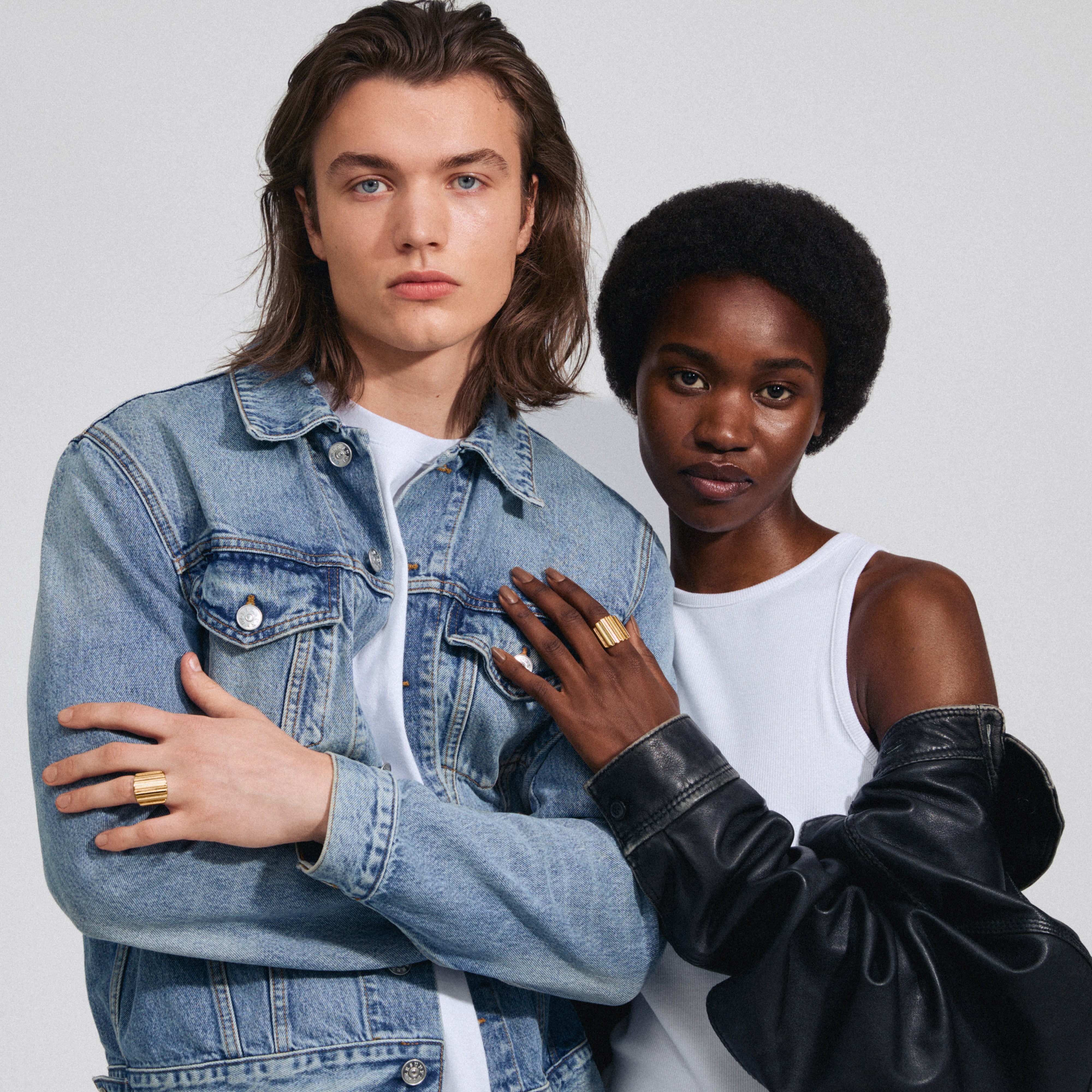 A man and woman pose, highlighting the LAUREL gold-plated ring's wavy design, embodying edgy urban style, adjustable for a personalized fit.