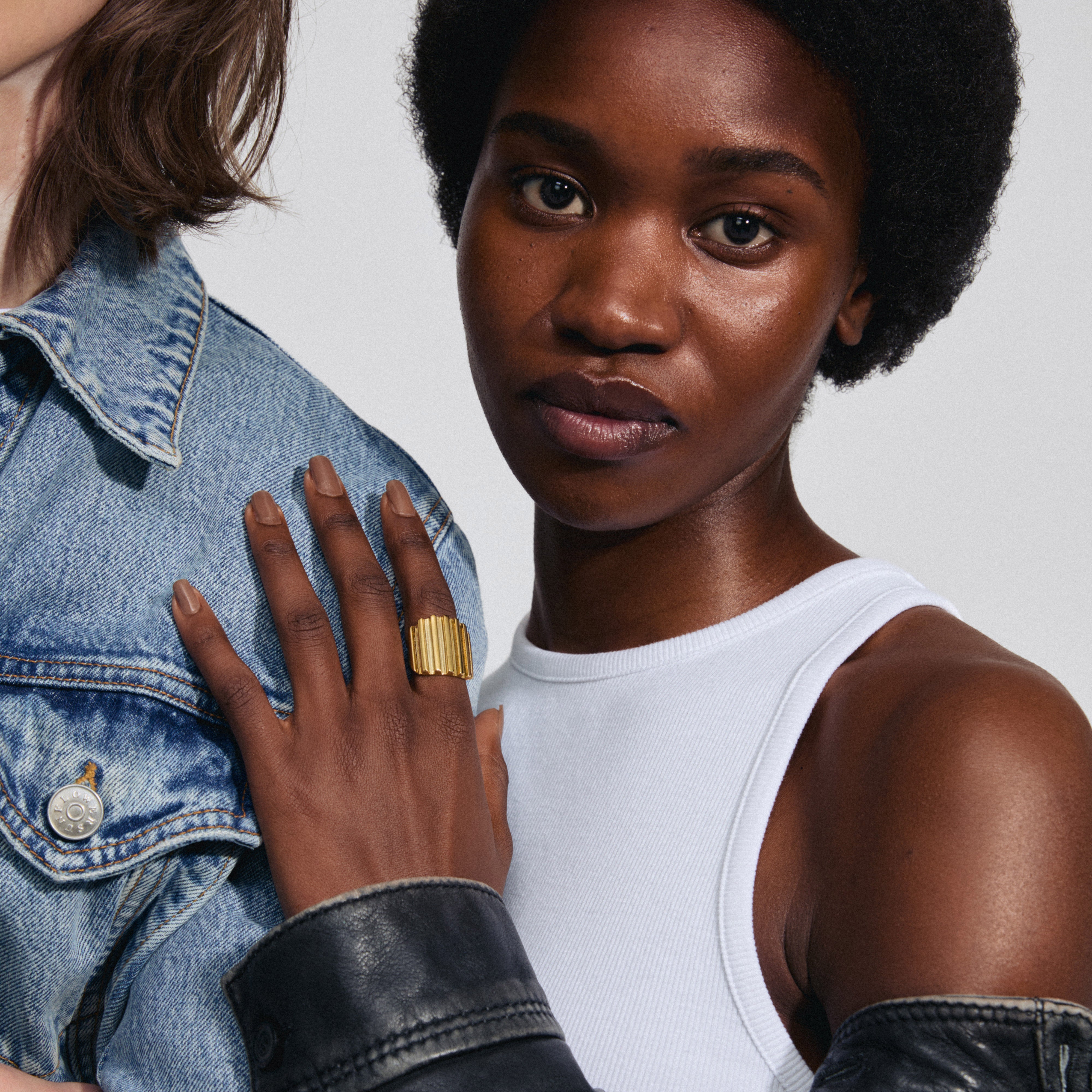 Close-up of a woman's hand wearing the LAUREL ring, a gold-plated statement piece with a wavy design from Pilgrim's edgy, urban collection.