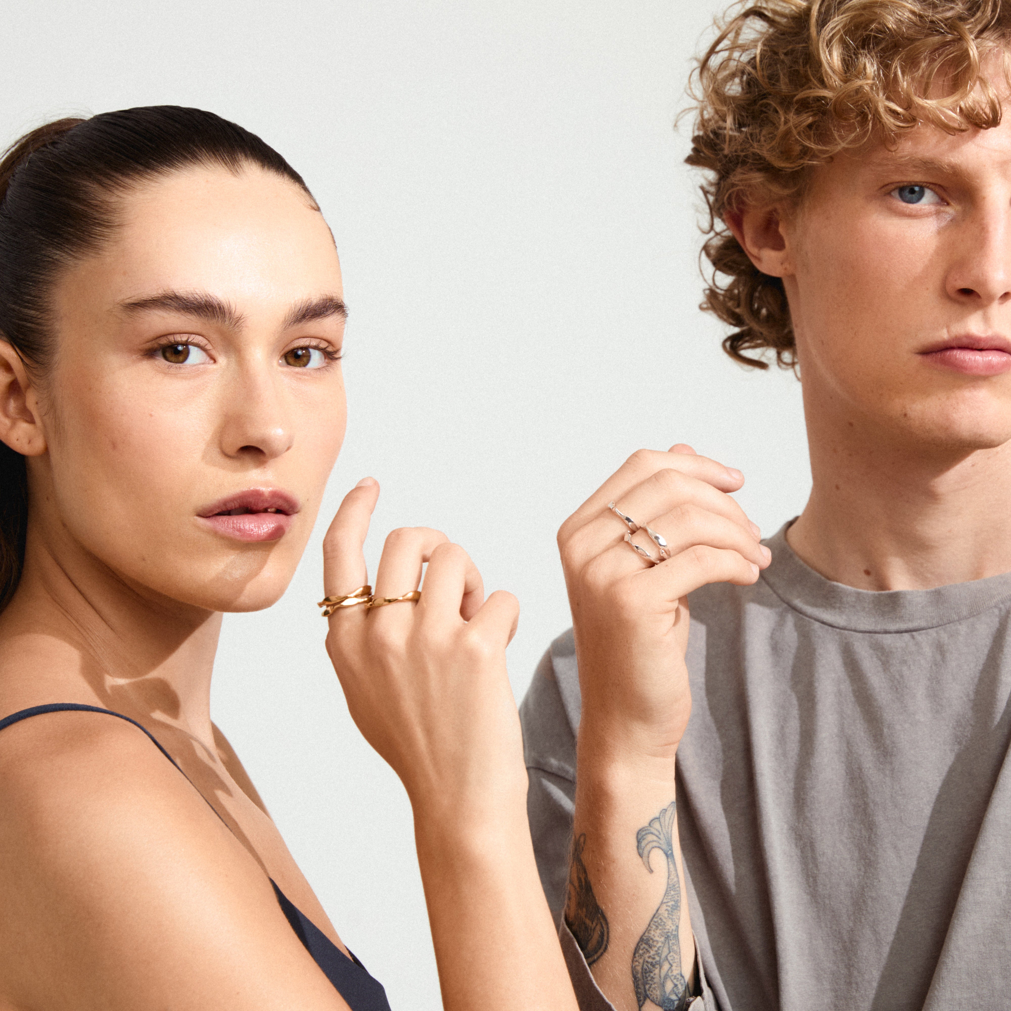 Man and woman showcasing WYATT rings, 3-in-1 gold-plated set by Pilgrim, highlighting adjustable, bold design with a chic, handcrafted look.