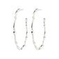 Silver-plated WYATT hoop earrings feature a wavy, handcrafted design, offering sophisticated versatility for daily wear and special occasions. Crafted from 98% recycled materials.