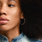 Close-up of a woman wearing the WYATT silver-plated hoop earrings by Pilgrim, showcasing their wavy, handcrafted design.