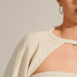 Close-up of a person wearing Pilgrim's NAJA large gold-plated hoop earring, showcasing its elegant twisted design that reflects light beautifully.