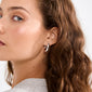 MADDIE chunky hoop earrings in silver-plated finish on a young woman’s ear, highlighting their glossy, bold design perfect for adding a trendy touch.
