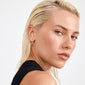 Young woman showcases APRIL small gold-plated hoop earrings by Pilgrim, highlighting their elegant simplicity against a neutral background, complementing her slicked-back hair and minimalist style.