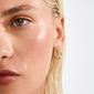 Close-up of a person wearing APRIL small hoop earrings silver-plated, showcasing a sleek, minimalist design ideal for versatile, personal style from Pilgrim.