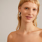JULITA semi-hoop earrings, silver-plated, showcasing organic, handcrafted shapes, worn by a woman with blonde hair, highlighting Pilgrim's timeless and powerful design.