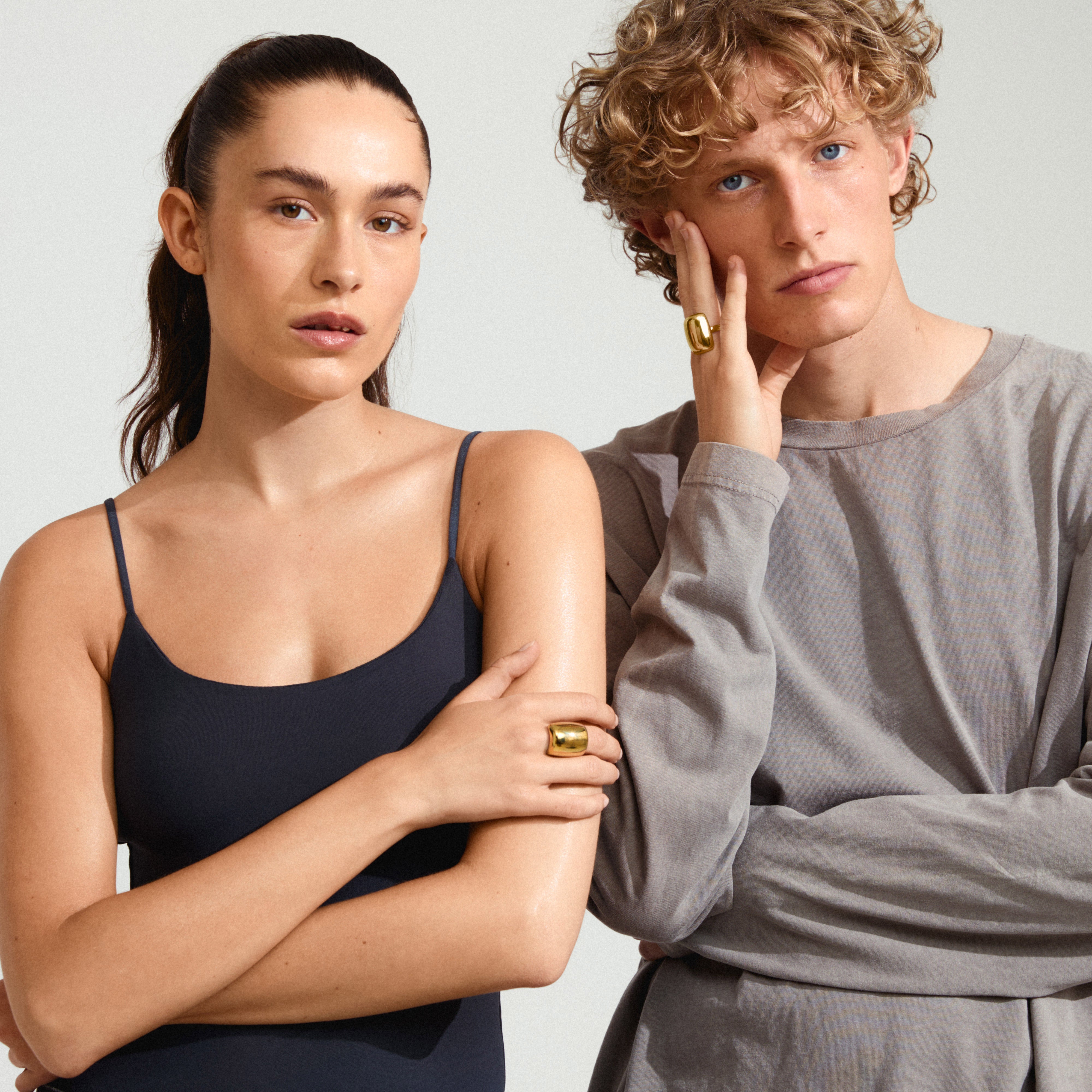 KIERAN ring gold-plated, chunky and stylish, worn by a woman in a black tank top, showcasing its bold and confident design. Adjustable and sustainable.