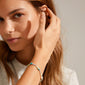 Woman with long hair wearing the INDIANA bracelet mint, showcasing freshwater pearls, grey agate, turquoise, and glass beads, embodying an organic, trendy style.