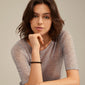 Woman wearing the POWERSTONE bracelet with round black agate stones on her wrist, showcasing its timeless and versatile design.