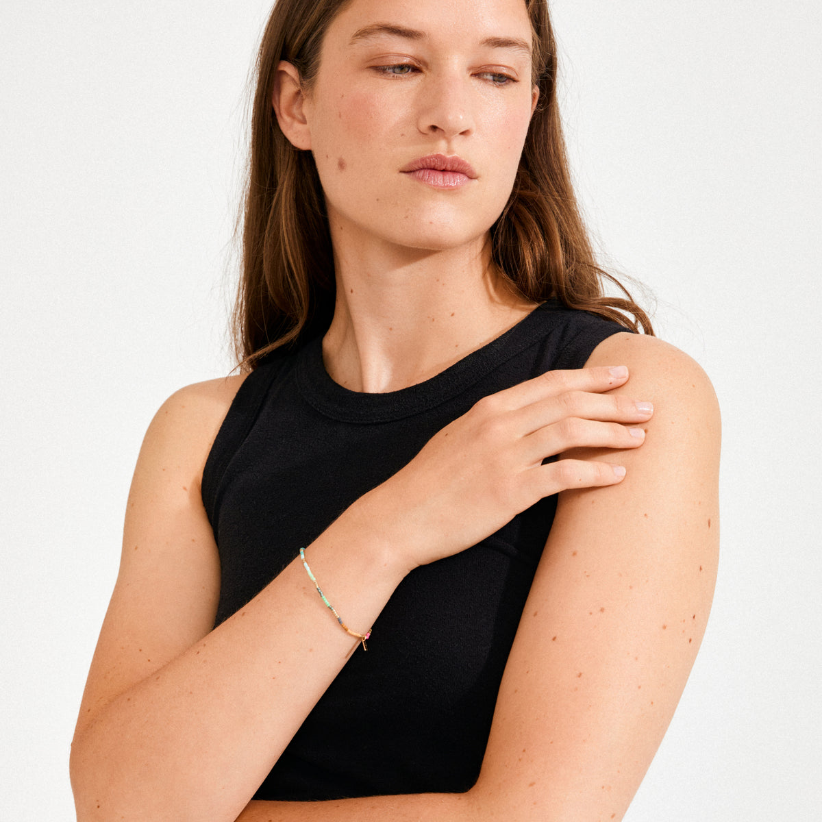 Young woman models the ALISON bracelet, showcasing its vibrant multicolored glass beads on a stretchy band, embodying Pilgrim's boho-chic style and festival energy.